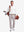 Front full body shot of model wearing white solid stretch cotton pique long sleeve polo shirt while carrying a golf bag on back