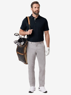 Front full body shot of model wearing navy  ultra-comfort slim fit roma knit polo shirts with golf bag on back