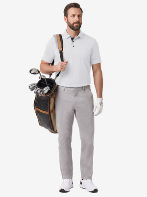Front full body shot of model wearing white  ultra-comfort slim fit roma knit polo shirts with golf bag on back