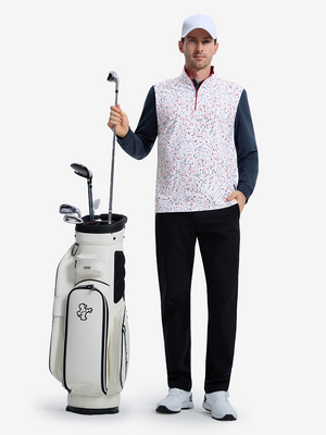 Front full body shot of model wearing white polka dots full print quarter zip sleeveless vest pullover with a golf club in hand and golf bag beside