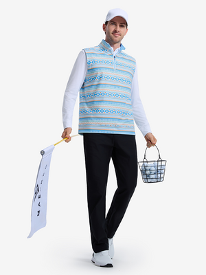 Front full body shot of model wearing blue ethnic full print quarter zip sleeveless vest pullover holding a flag in one hand and a basket of golf balls in the other hand