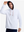 Front upper body shot of model wearing white soft stretchy hoodie with inner print hood and pulling the hood with one hand