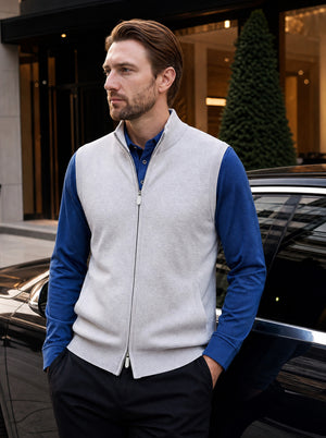 Men's Mist Gray Wool Blend Full Zip Sweater Vest Styled Over a Blue Long Sleeve Shirt with Black Pants, Featuring a Refined Casual Look in an Outdoor Lifestyle Setting