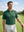 Front upper body shot of male model wearing green classic lightweight jacquard golf shirt and looking into the distance on the golf course